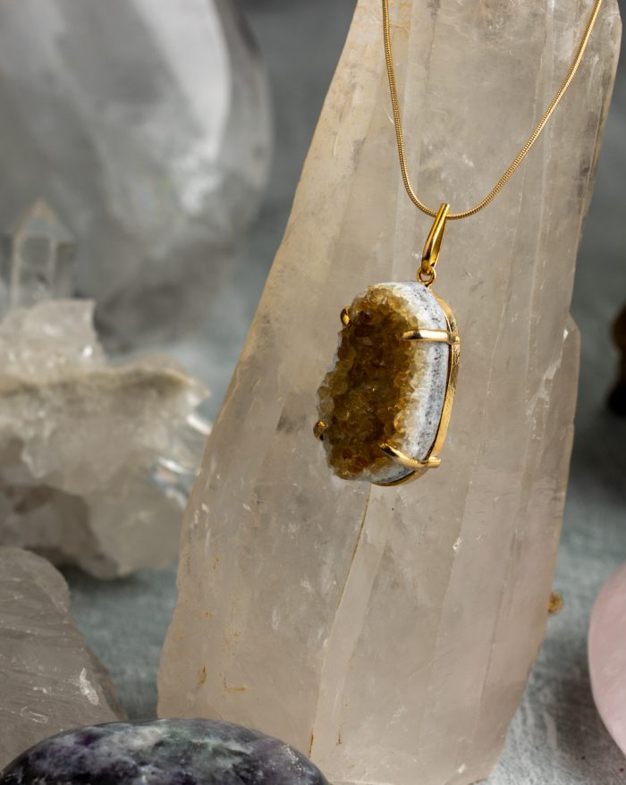 "Handmade gold-plated pendant with raw crystal gemstone in unique shapes, perfect as a birthstone piece.