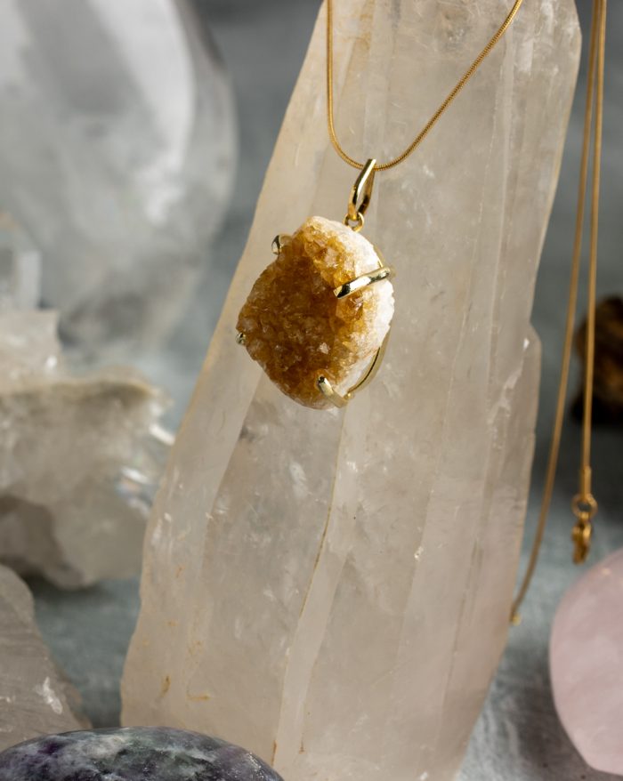 "Handmade gold-plated pendant with raw crystal gemstone in unique shapes, perfect as a birthstone piece.