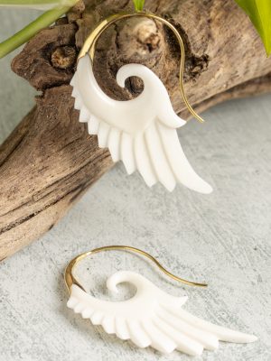 "Hand-carved feather earrings and ring in gold-plated and silver versions, crafted from bone with fine details, inspired by Bali's artistry.