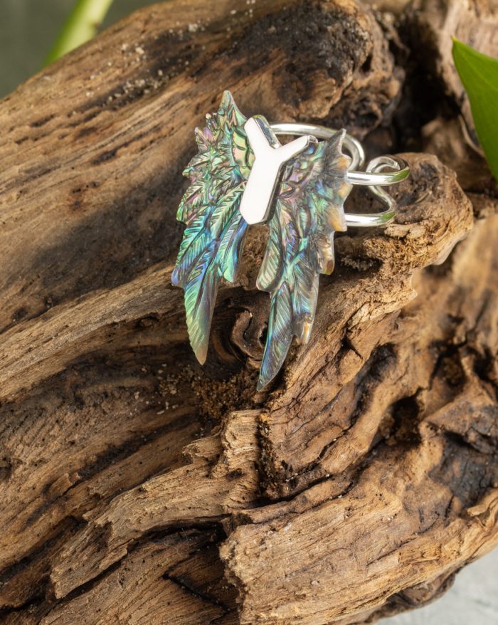 Hand-carved silver feather ring from the Bali collection, available in abalone and bone versions, showcasing native craftsmanship.