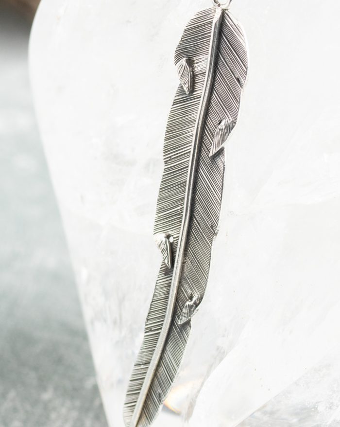 Handmade silver feather pendant with fine details, inspired by Bali's native artistry and crafted by artisans.