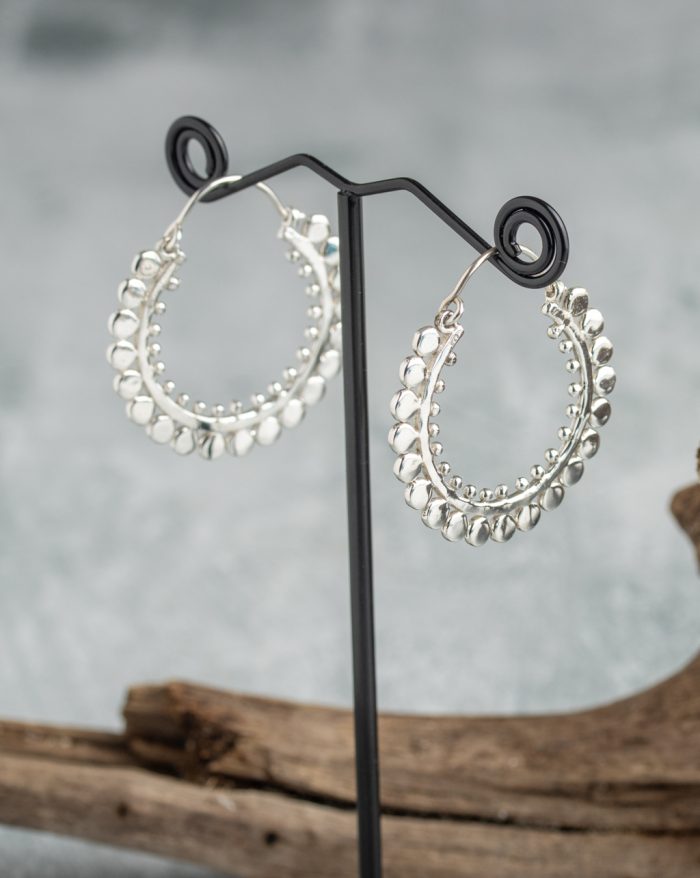 Handmade large silver hoop earrings with symmetrical design, inspired by Bali's native artistry.