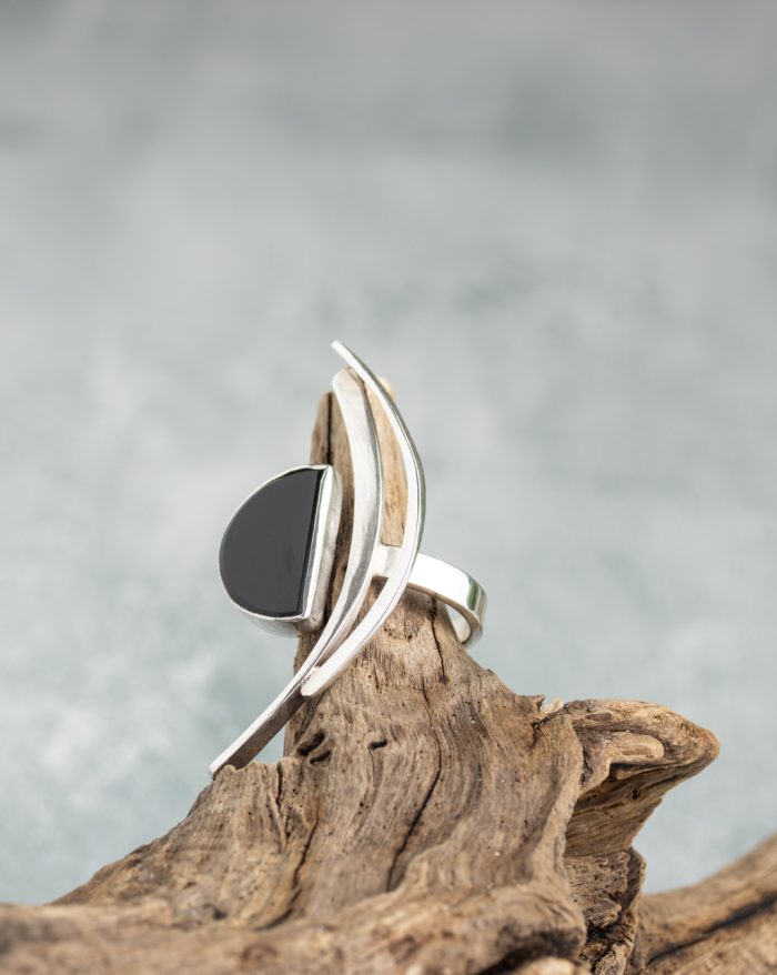 Handmade silver ring from the Brasil Collection featuring a black stone with long curves and half-moon and half-circle symbolic shapes.