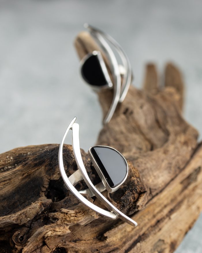 Handmade silver ring from the Brasil Collection featuring a black stone with long curves and half-moon and half-circle symbolic shapes.